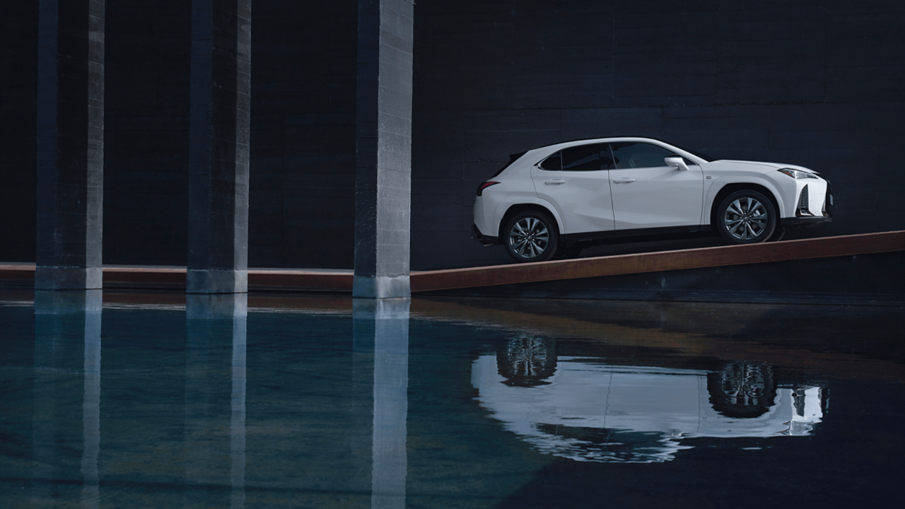 Side view of a parked Lexus UX next to water